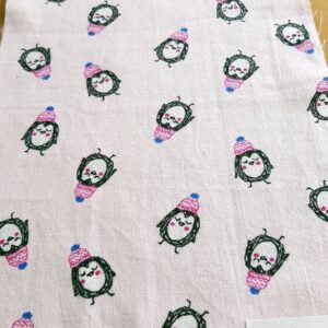 Cotton print fabric in penguin print, on a soft pastel base