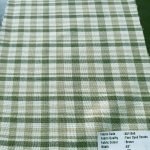 Bleeding madras fabric made by weaving yarns of several colors, in plaid patterns, with all yarns being dyed with vegetable dyes.