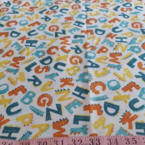 Novelty Print fabric with alphabets print and dinosaur tails, for children's clothing, quilting, dog bandanas and dresses.