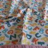 Novelty Print fabric with alphabets print and dinosaur tails, for children's clothing, quilting, dog bandanas and dresses.