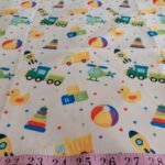 Cotton print fabric with dump trucks, trains, rockets, helicopters & ducks, for children's clothing, quilting, sewing and dresses.