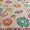 Cotton print fabric in donuts and icing theme, with several donuts, for children's clothing, quilting, sewing and dresses.