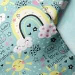 Novelty print fabric for children's clothing, dog bandanas and quilting, with rainbows, sunshine & clouds for sewing & crafts.