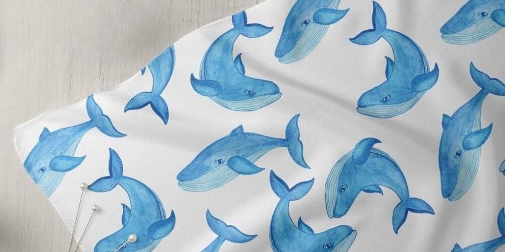 Novelty print fabric with blue whales print for dog bandanas, bows, vintage clothing, resort wear & children's clothing.